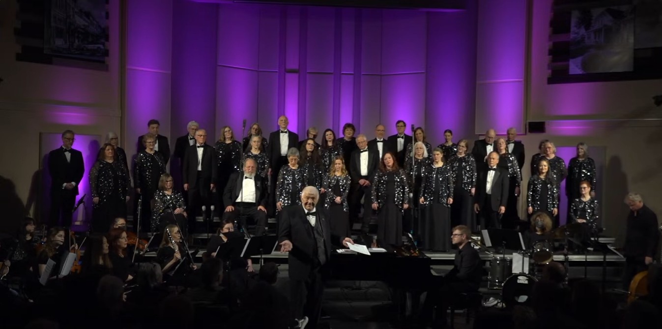 Seattle Breath of Aire Choir performing under purple stage lighting